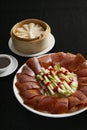 Peking duck with spring onion, cucumber and sweet bean sauce with pancakes, Beijing roast duck on black background