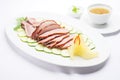 peking duck on white plate with cucumber slices