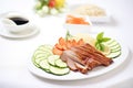 peking duck on white plate with cucumber slices