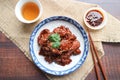 Peking Pork Chop - Chinese pork chop in sweet sauce and sesame served on the Chinese porcelain on the wooden background - Top view