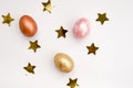 Pelamutra shiny, multi-colored Easter eggs, gold confetti on a white background. Golden egg. Happy Easter. Place for text. Flat la Royalty Free Stock Photo