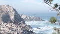 Pelicans flock, rocky cliff island, ocean, Point Lobos, California. Birds flying