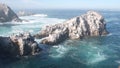 Pelicans flock, rocky cliff island, ocean, Point Lobos, California. Birds flying