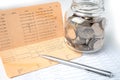 Pen on account book bank with coins in glass jar; Banking, Investment, economy, business. Royalty Free Stock Photo