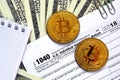 The pen, bitcoins and dollar bills is lies on the tax form 1040 Royalty Free Stock Photo