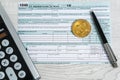 The pen, bitcoins and calculator on the tax form 1040 U.S. Individual Income Tax Return. The time to pay taxes Royalty Free Stock Photo