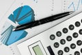 Pen and calculator on a background of diagrams Royalty Free Stock Photo