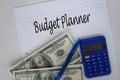 A pen, calculator, US dollar money with text BUDGET PLANNER on a paper Royalty Free Stock Photo