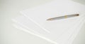 A pen on clean white blank sheets of paper on the table Royalty Free Stock Photo