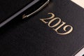 A pen on a closed black notebook diary with the inscription 2019 Royalty Free Stock Photo