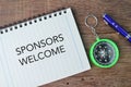 Pen, compass and notebook written with text SPONSORS WELCOME Royalty Free Stock Photo