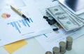 Pen on finance chart document with coins and dollars. Royalty Free Stock Photo