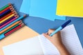 A pen in the hand of a child writing in a school notebook on a Desk with school supplies, top view Royalty Free Stock Photo