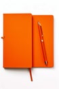 Pen is laying on orange notebook with red cover. Generative AI Royalty Free Stock Photo