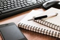 Pen on notebook with computer keyboard, mouse and cell phone Royalty Free Stock Photo