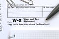 The pen and notebook on the tax form W-2 Wage and Tax Statement. The time to pay taxes Royalty Free Stock Photo