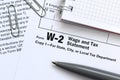 The pen and notebook on the tax form W-2 Wage and Tax Statement. The time to pay taxes Royalty Free Stock Photo