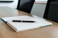 Pen on notepad for agenda kept on table in corporate conference room Royalty Free Stock Photo
