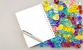 Notepad and pen with gems on gray background Royalty Free Stock Photo