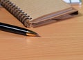 Pen with notepad on wooden table. Royalty Free Stock Photo