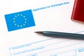 Pen and passport on blank European Union Schengen visa application form. Tourism and travel in Europe concept Royalty Free Stock Photo