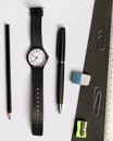 Pen, pencil, eraser, pencil sharpener, wristwatch and ruler on a contrasting black and white background Royalty Free Stock Photo