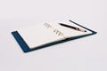 A pen is placed on a diary of blank notes, against the background.