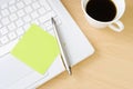 Pen with postit note, laptop and cup of coffee Royalty Free Stock Photo