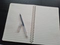 Black pen on white notebook. Stock photo. Download image