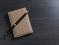 A pen and small daily note on a black table