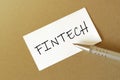 Pen, white paper with text FINTECH on the brown background Royalty Free Stock Photo