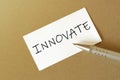 Pen, white paper with text INNOVATE on the brown background Royalty Free Stock Photo