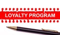 Pen and white torn paper strip on a bright red background with the text LOYALTY PROGRAM