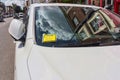 Penalty charge notice (parking fine) attached to windscreen of white car parked in high street London England