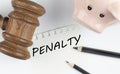 PENALTY text on paper with gavel and piggi bank