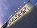 Penang, Malaysia - April 08, 2021 : External building facade view of a Tesco store signage lighted up during sunset at Udini