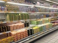 A variety of cheeses and butter are displayed on sales shelves in hypermarkets.