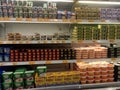 A variety of cheeses and butter are displayed on sales shelves in hypermarkets.