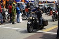Motorcyclists ride high-powered motorcycles through crowded areas.