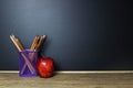 Pencil in basket and red apple on wood table with Blackboard Royalty Free Stock Photo