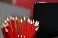 Pencil box and scattered red pencils and black portable computer. Stock photo