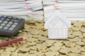 Pencil and calculator with house on stack of gold coins Royalty Free Stock Photo