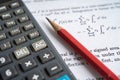 Pencil and calculator on mathematic formula exercise test paper in education school Royalty Free Stock Photo