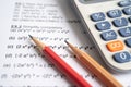 Pencil and calculator on mathematic formula exercise test paper in education school Royalty Free Stock Photo
