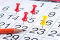 Close up of a Calendar Page with Pushpins and a Pencil Royalty Free Stock Photo