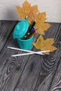 A pencil case in the form of a trash can. It contains colored pencils. Dried maple leaves are added to the compositions. Shot from Royalty Free Stock Photo