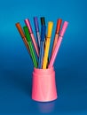 Pencil case with multi-colored pens on a blue background Royalty Free Stock Photo