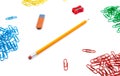 Pencil, eraser, sharpener, paper clips lie in different angles of the sheet on a white background. Hero image and copy space Royalty Free Stock Photo
