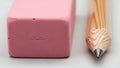 Pencil and eraser on white surface displaying writing or educational concept Royalty Free Stock Photo