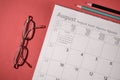 Pencil and glasses on calendar on a red background. personal agenda setting management